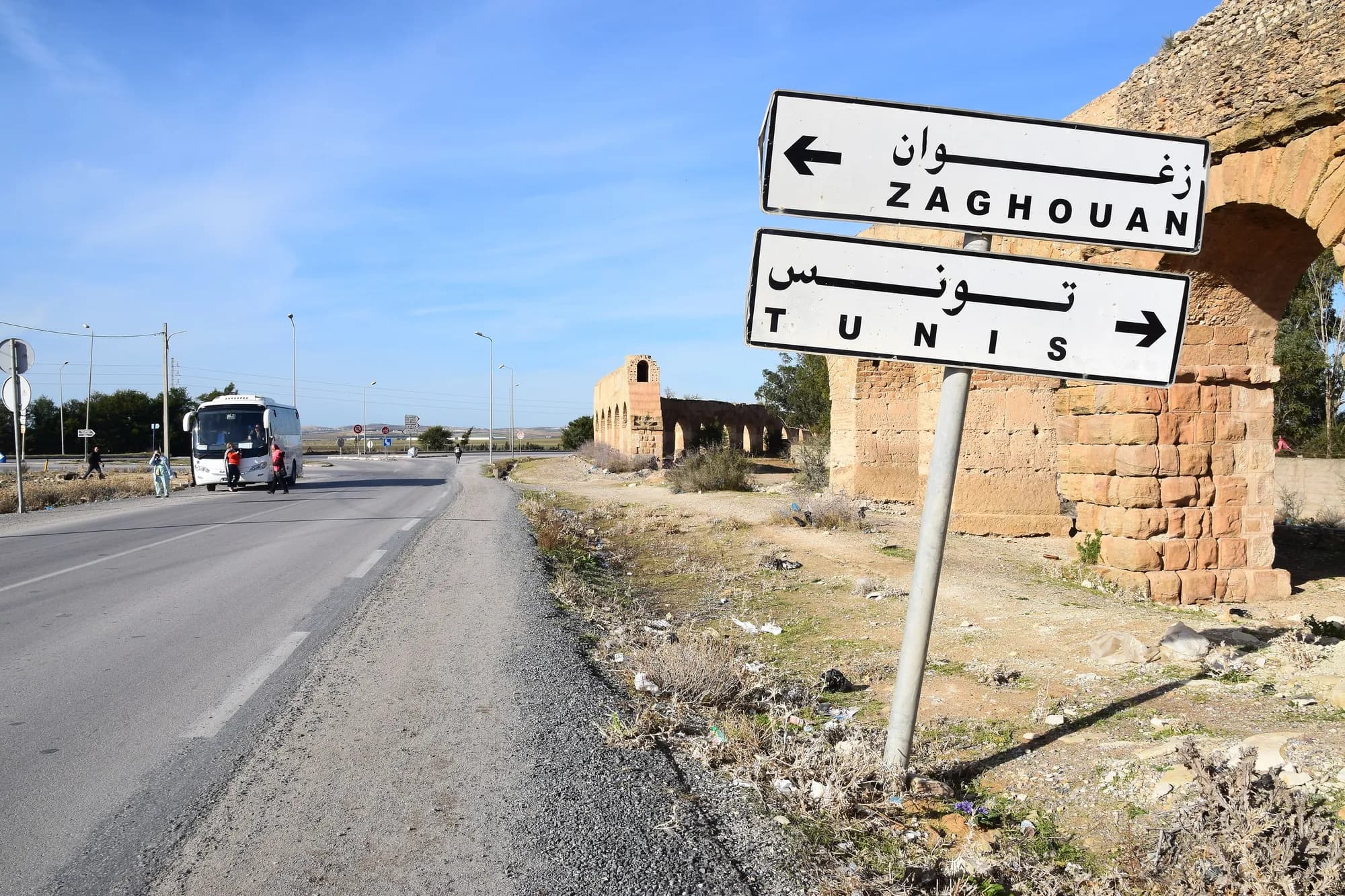 Road sign to Zaghouan and Tunis beside a Roman aqueduct