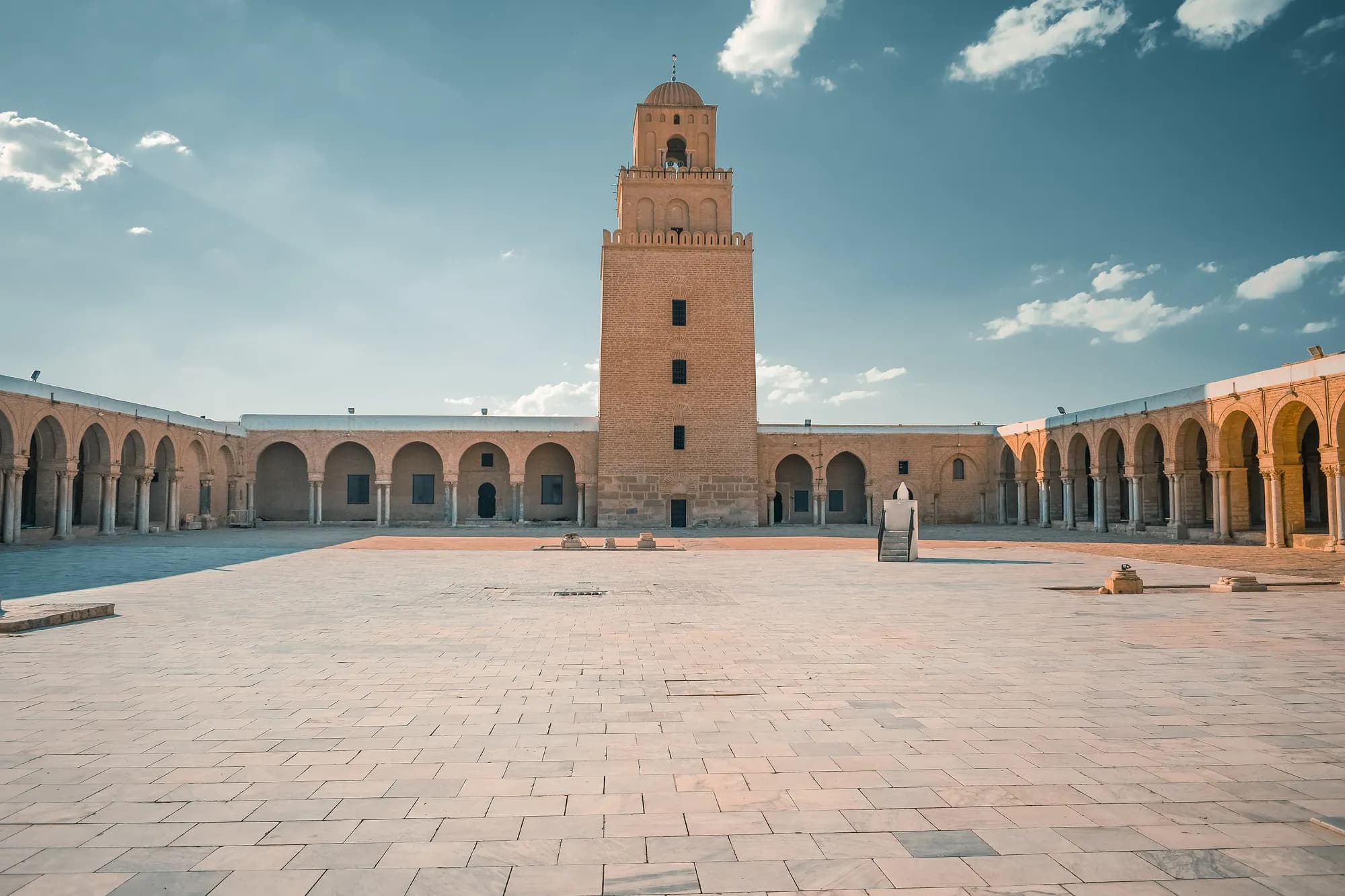 Courtyard of the Great Mosque of Kairouan under a blue sky